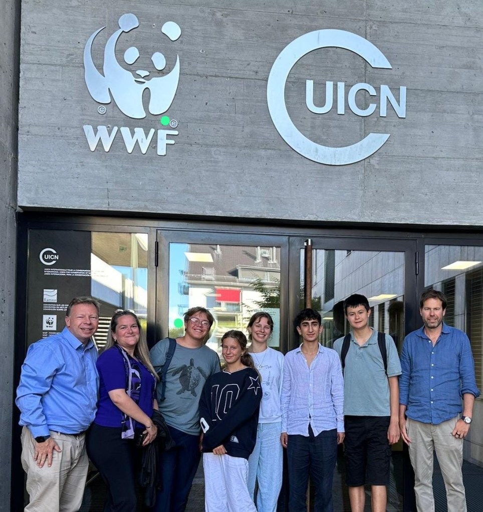 The OECM team standing together at the entrance to the WWF and IUCN building
