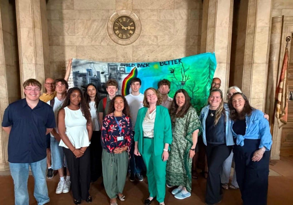 Participants standing together in the Guildhall foyer in front of a hand-painted banner reading Build Back Better